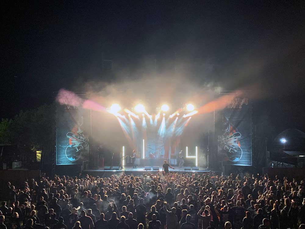 Publikum vor einer lebendig beleuchteten Festivalb&uuml;hne